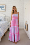 Front view of woman wearing pink and blue striped tiered maxi dress