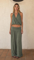 Front view of woman wearing sage green halter crop top and wide leg pants set