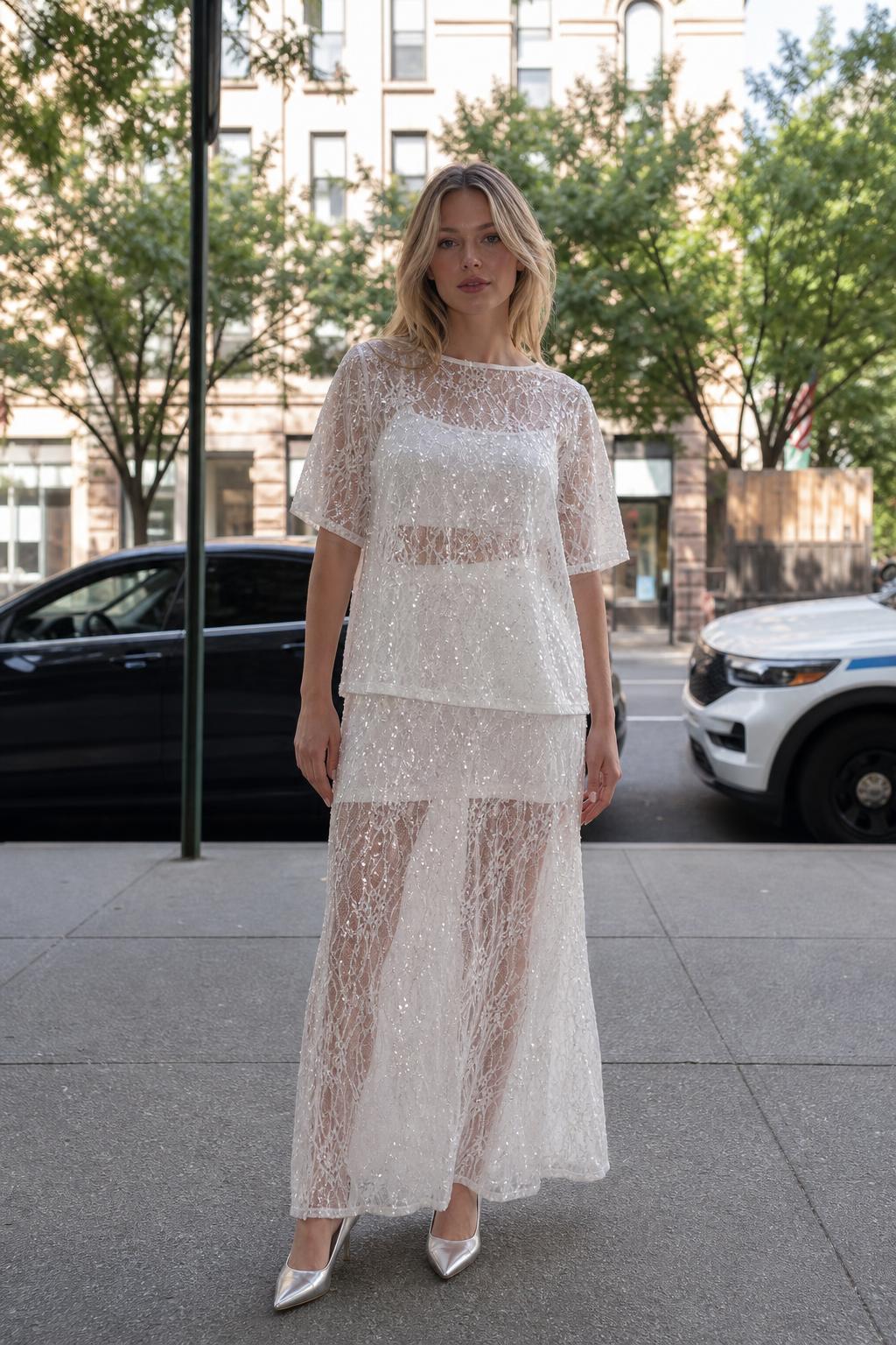Front view of woman wearing white sheer sequin lace two-piece set outdoors