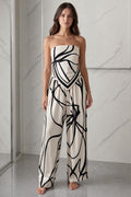 Front view of woman wearing beige and black abstract print strapless jumpsuit