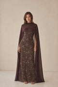 Front view of model wearing brown beaded maxi dress with cape