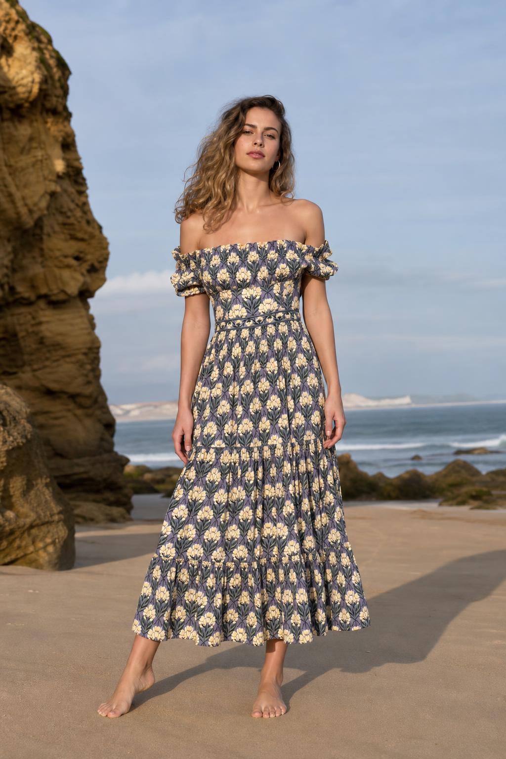 Front view of woman wearing blue floral off-the-shoulder midi dress on a beach