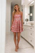 Front full view of woman wearing red paisley mini dress