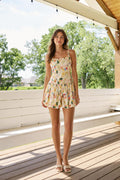 Front view of woman wearing cream floral print mini dress romper