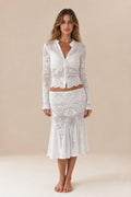 Front view of woman wearing white crochet lace cardigan and midi skirt set