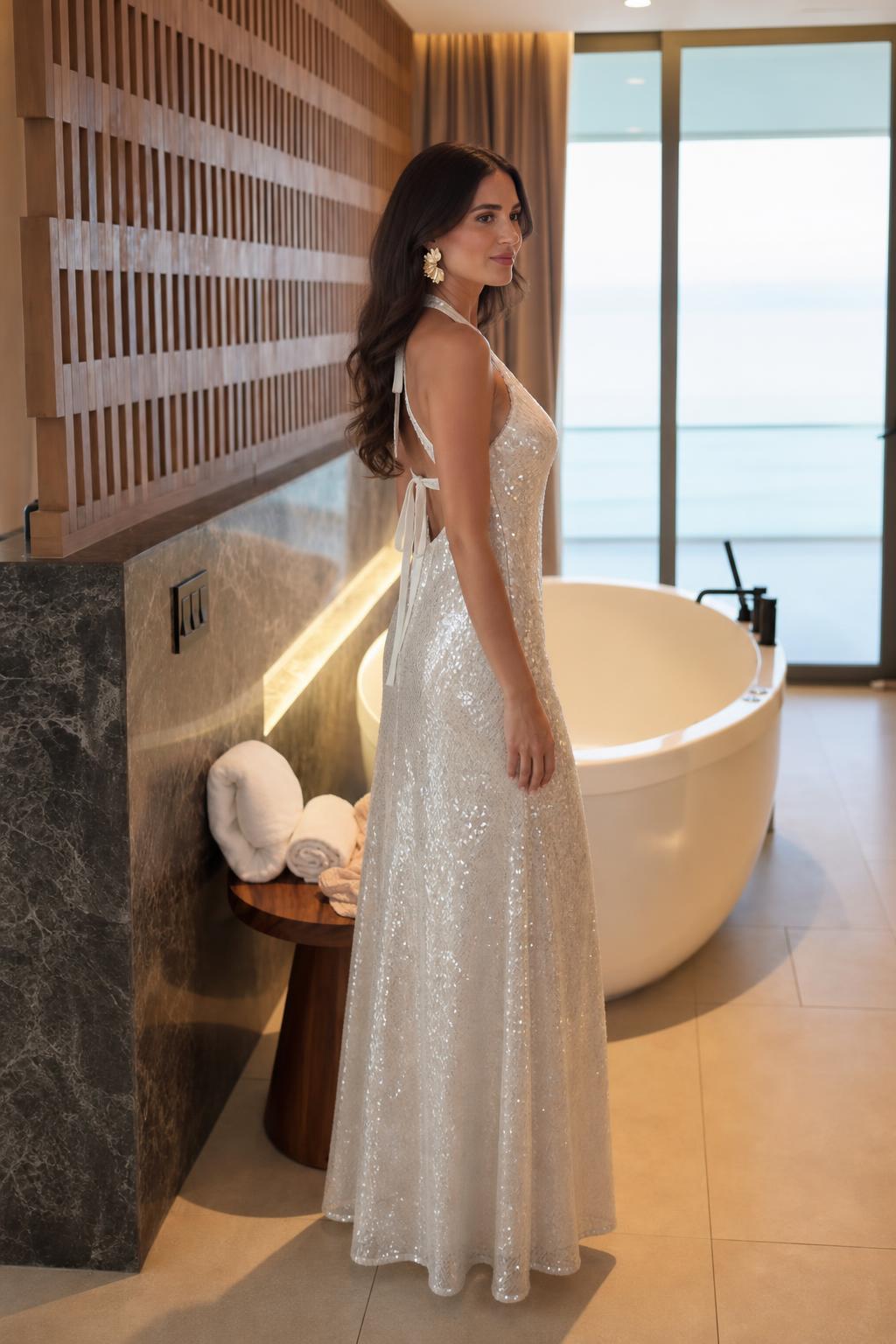 Model wearing white sequin halter maxi dress from the side