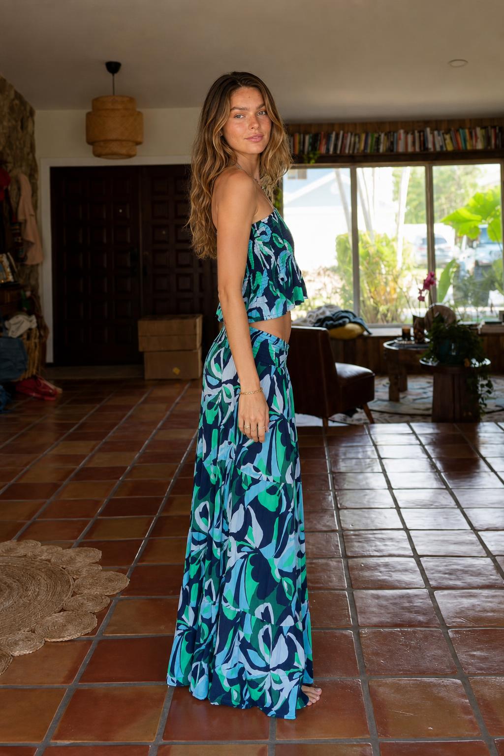 Side view of model wearing blue tropical print two-piece set