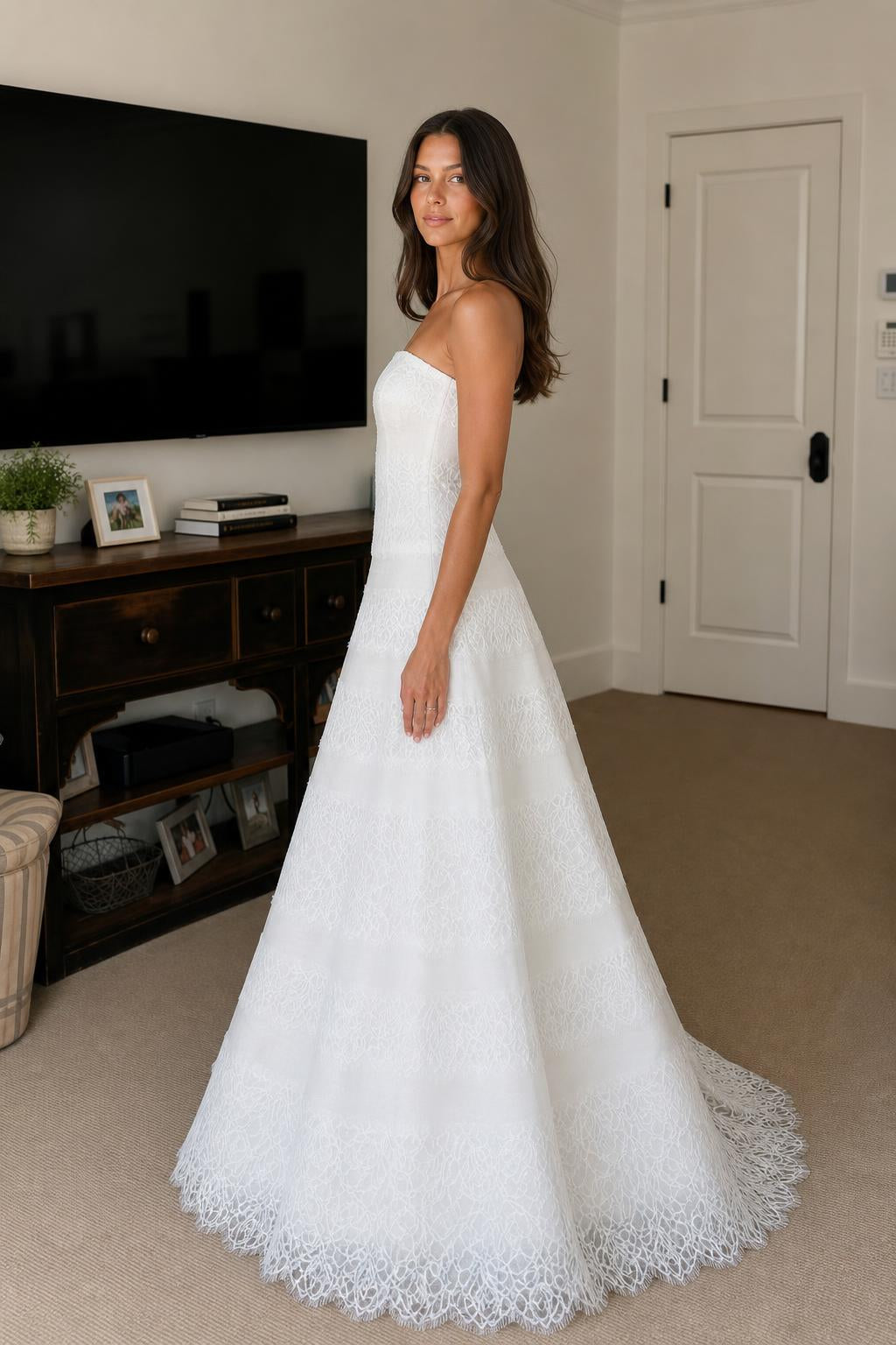 Side profile view of white strapless tiered lace evening dress