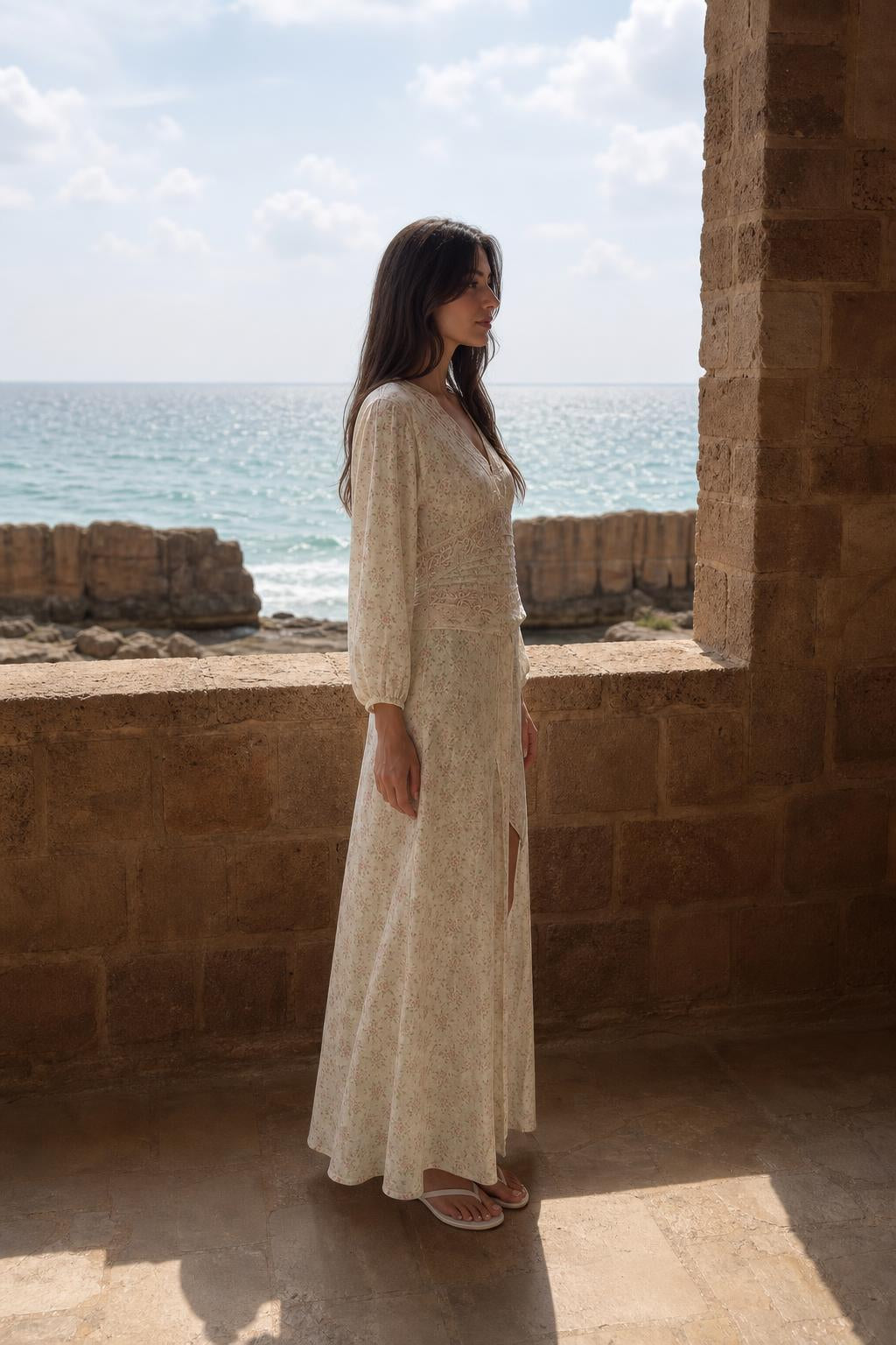 Side profile view of cream maxi dress with front slit