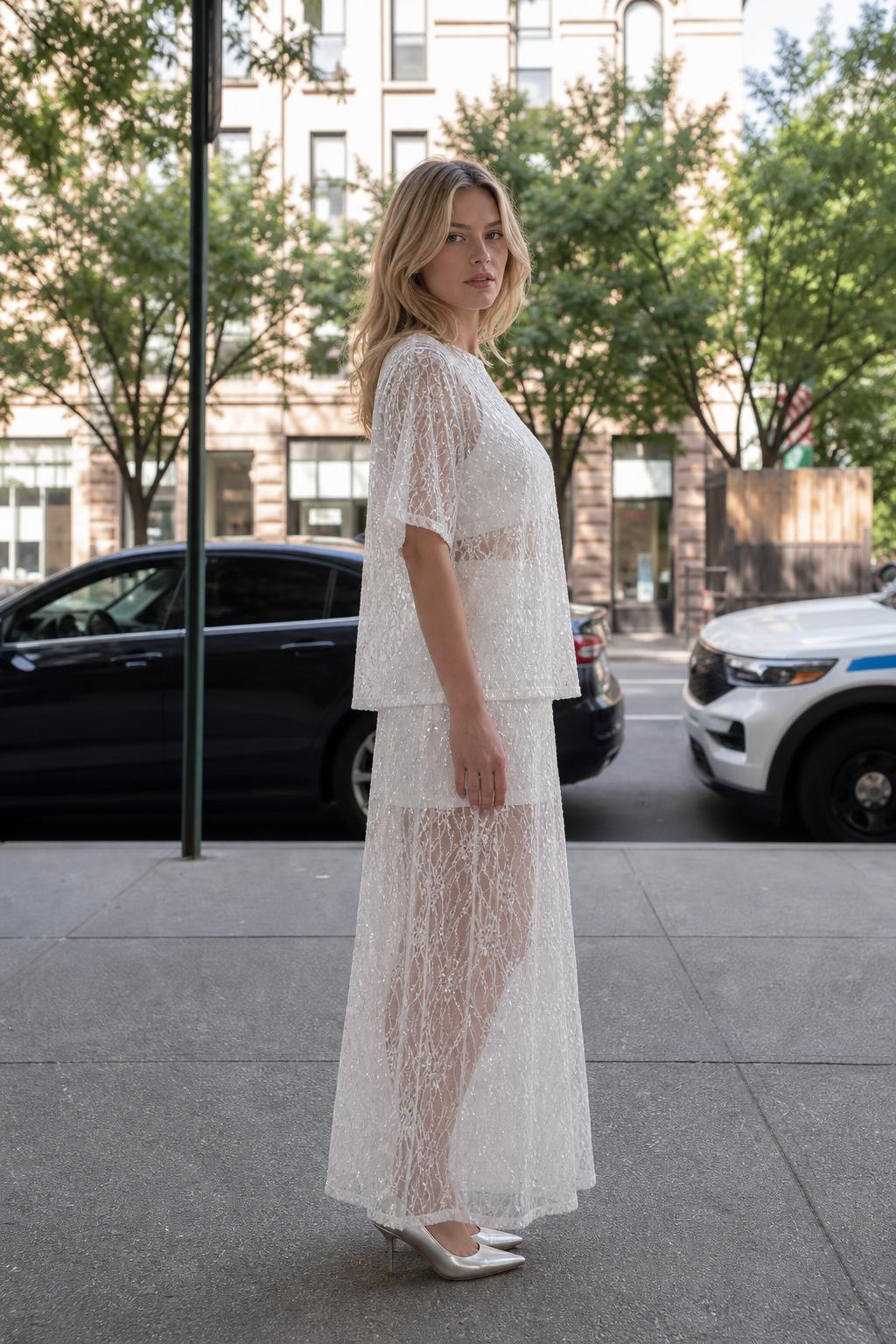 Side profile view of woman in white sequin lace matching set