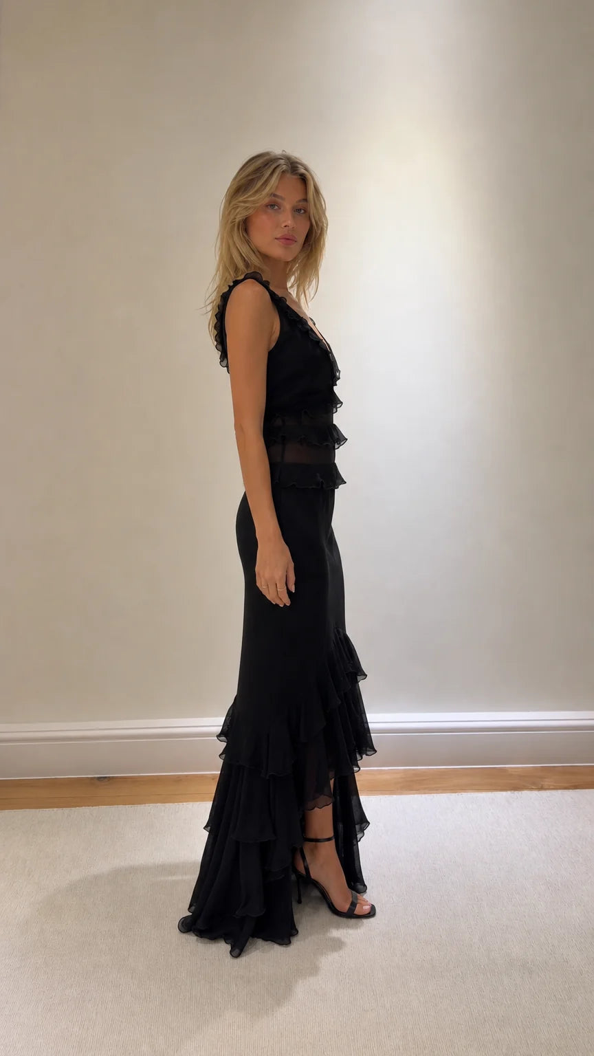 Side profile of black ruffled maxi dress with heels