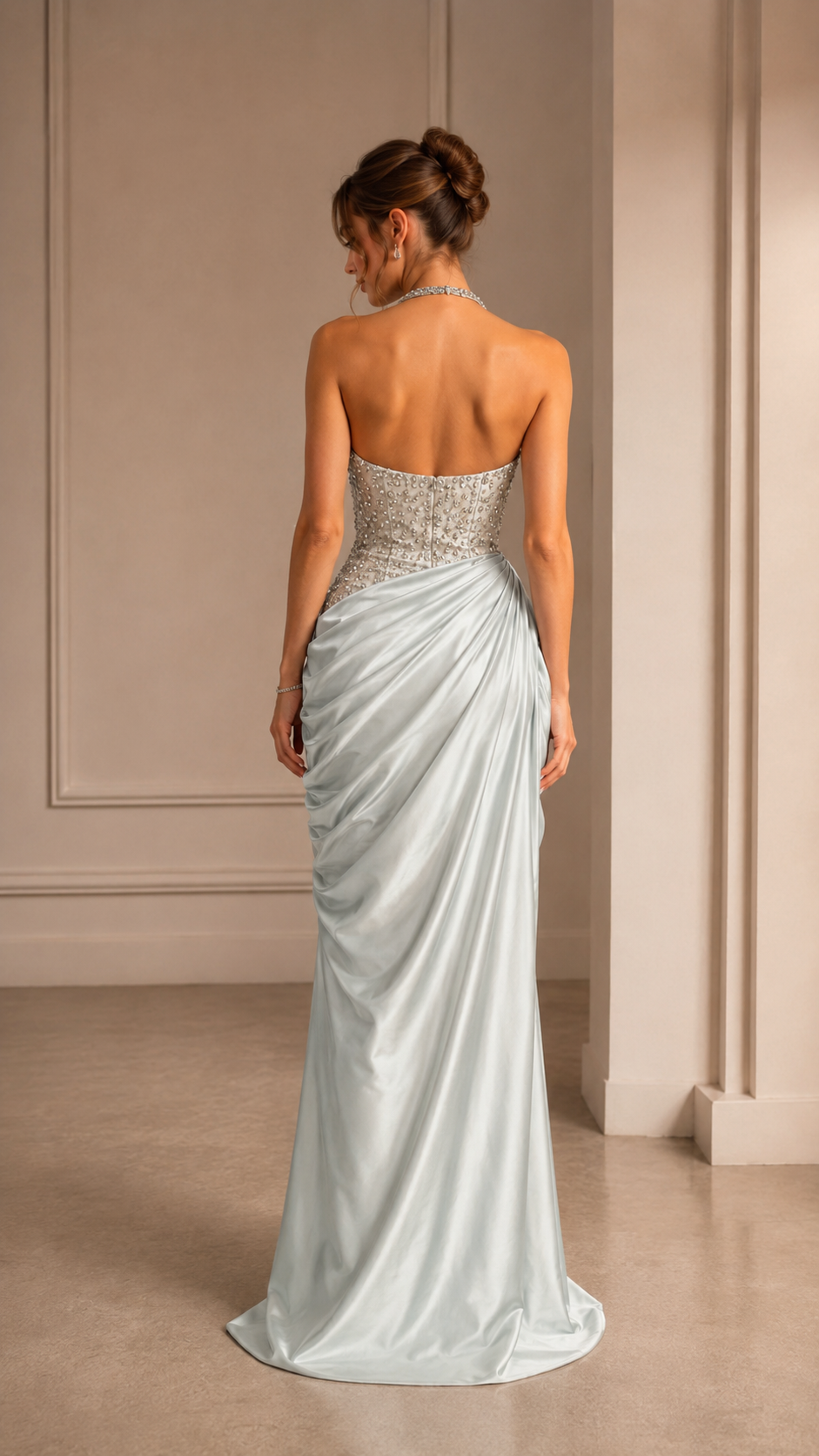 Back view of ice blue halter evening dress with fitted embellished bodice and draped skirt