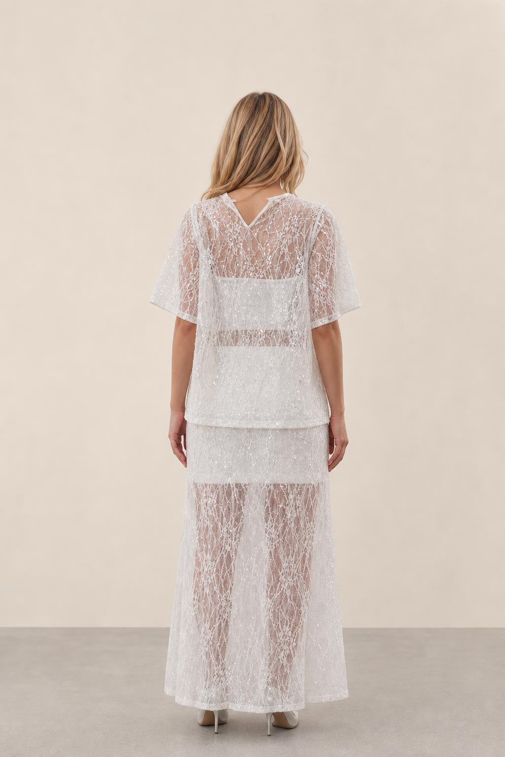 Back view of woman wearing white lace two-piece outfit