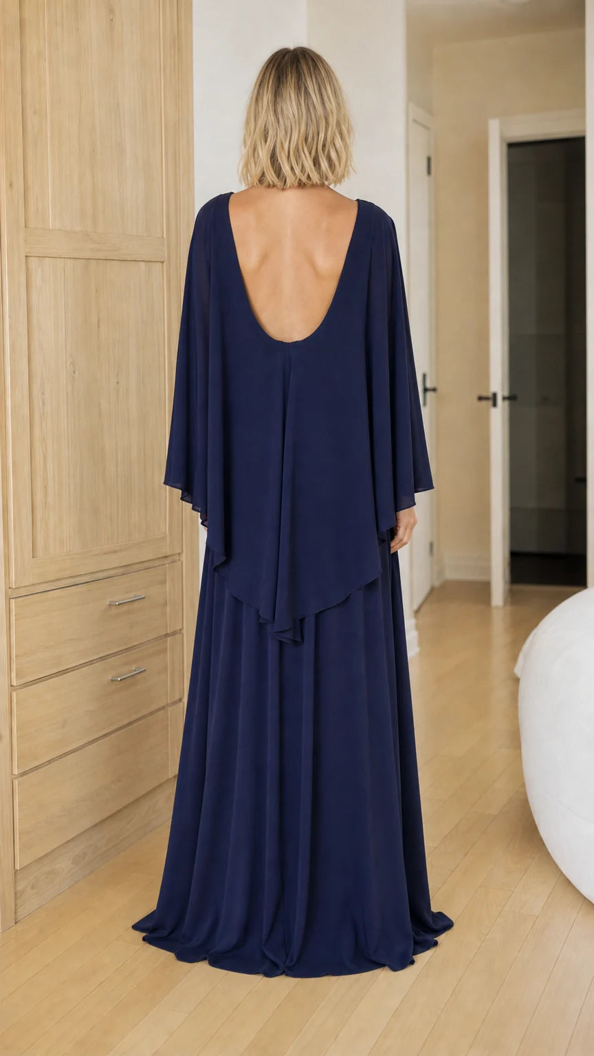 Back view of navy blue formal dress featuring scoop back and cape