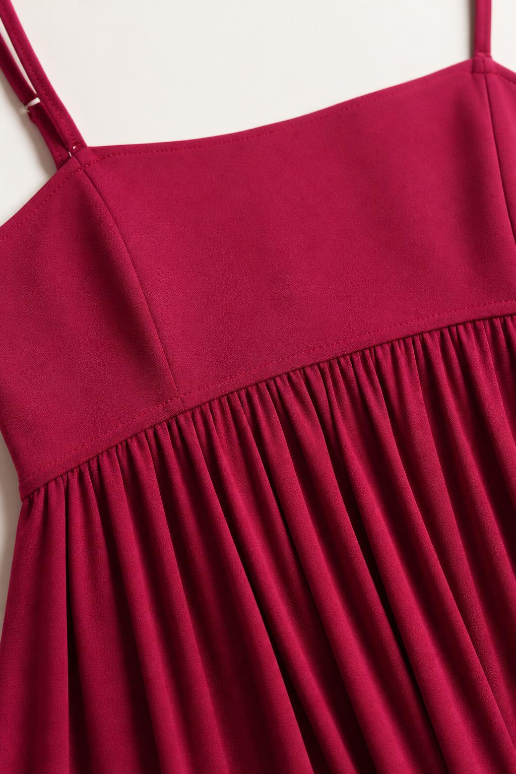 Close-up detail of the square neckline and gathered empire waist on fuchsia dress