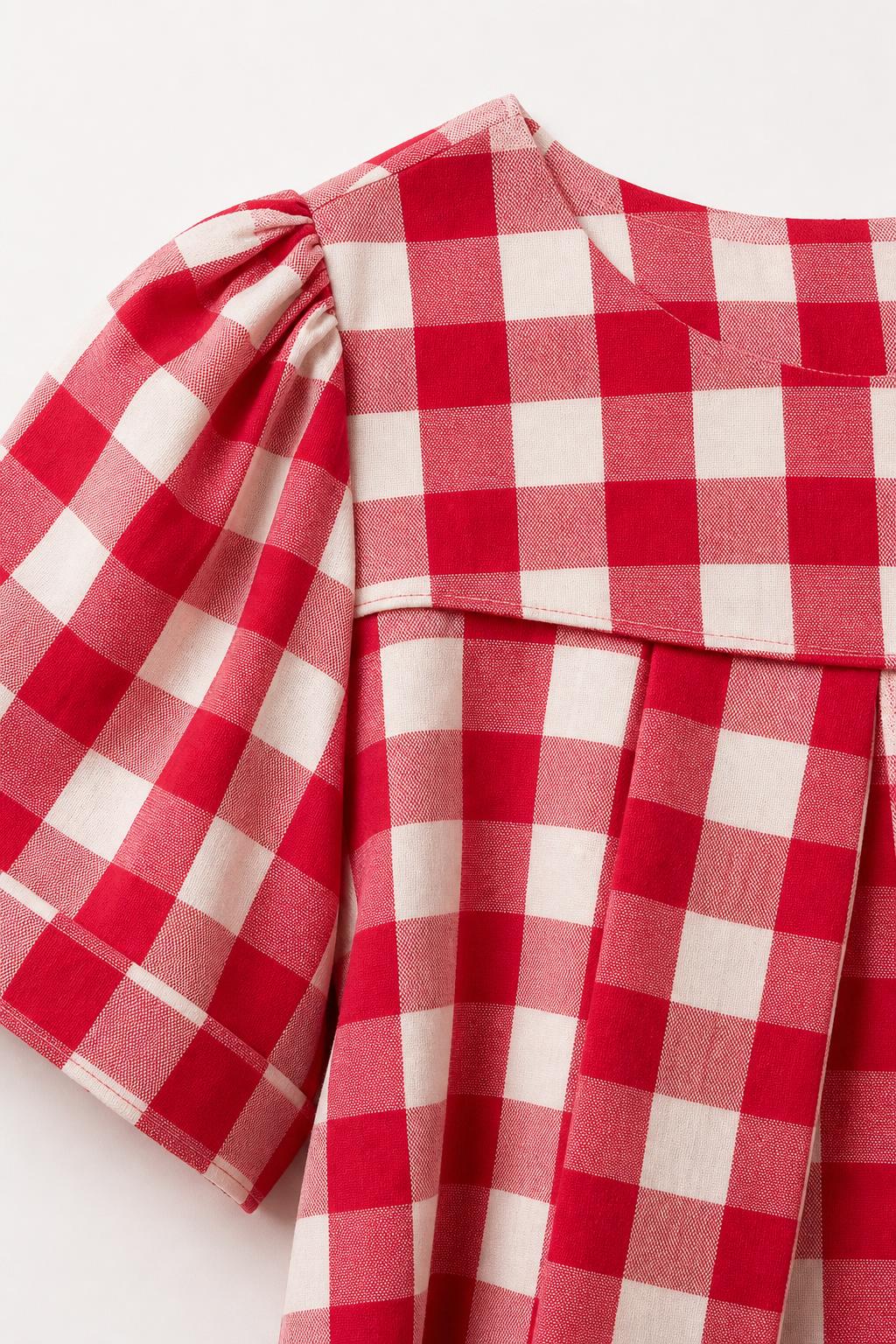 Close-up detail of red gingham check fabric and shoulder pleats