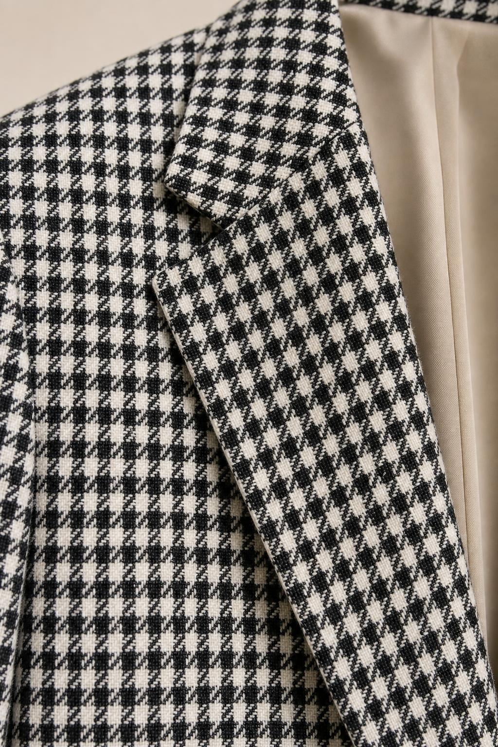 Close-up detail of the woven houndstooth fabric texture and lapel