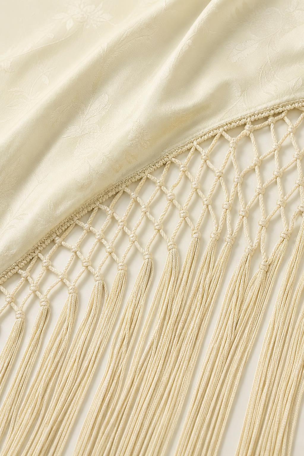 Close-up detail of the fabric texture and macrame fringe hem