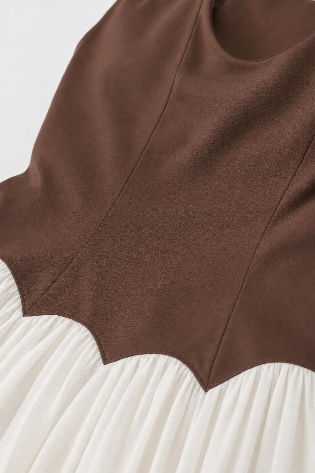 Close-up of the scalloped waist seam detail on brown and white maxi dress