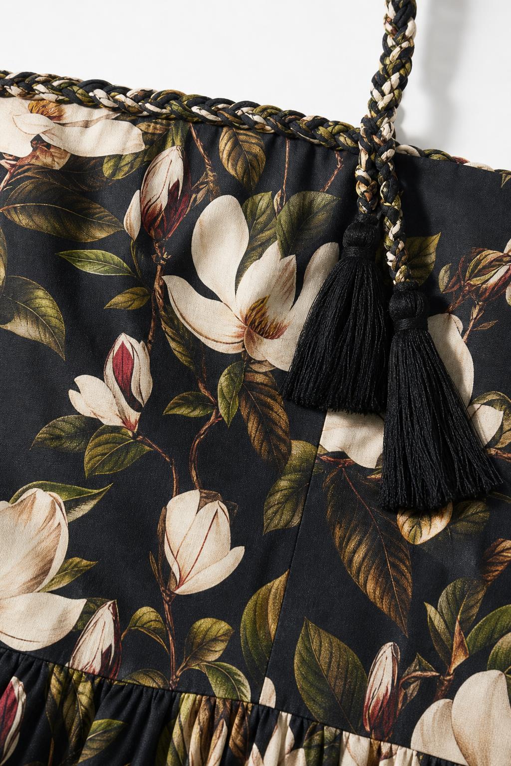 Close-up of fabric pattern, braided strap, and tassel detail