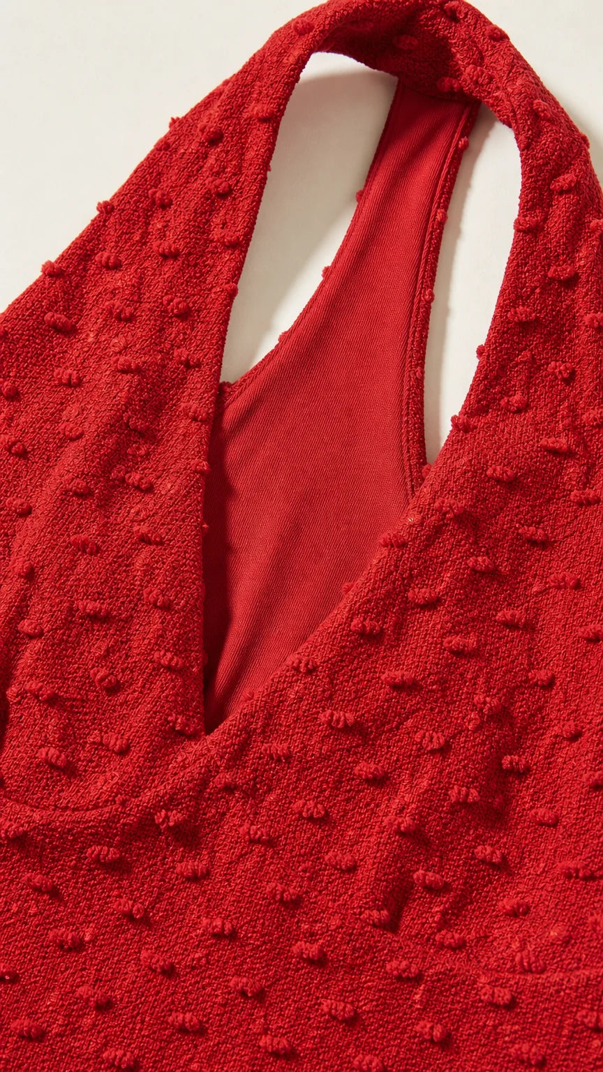 Close-up of red textured fabric and halter neckline construction