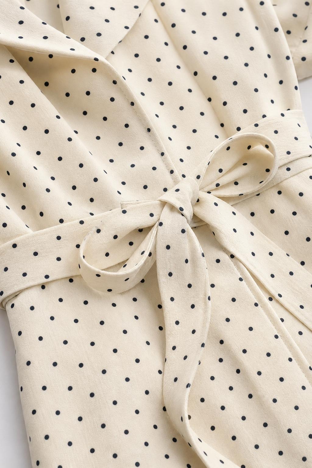 Close-up of polka dot fabric pattern and waist tie detail