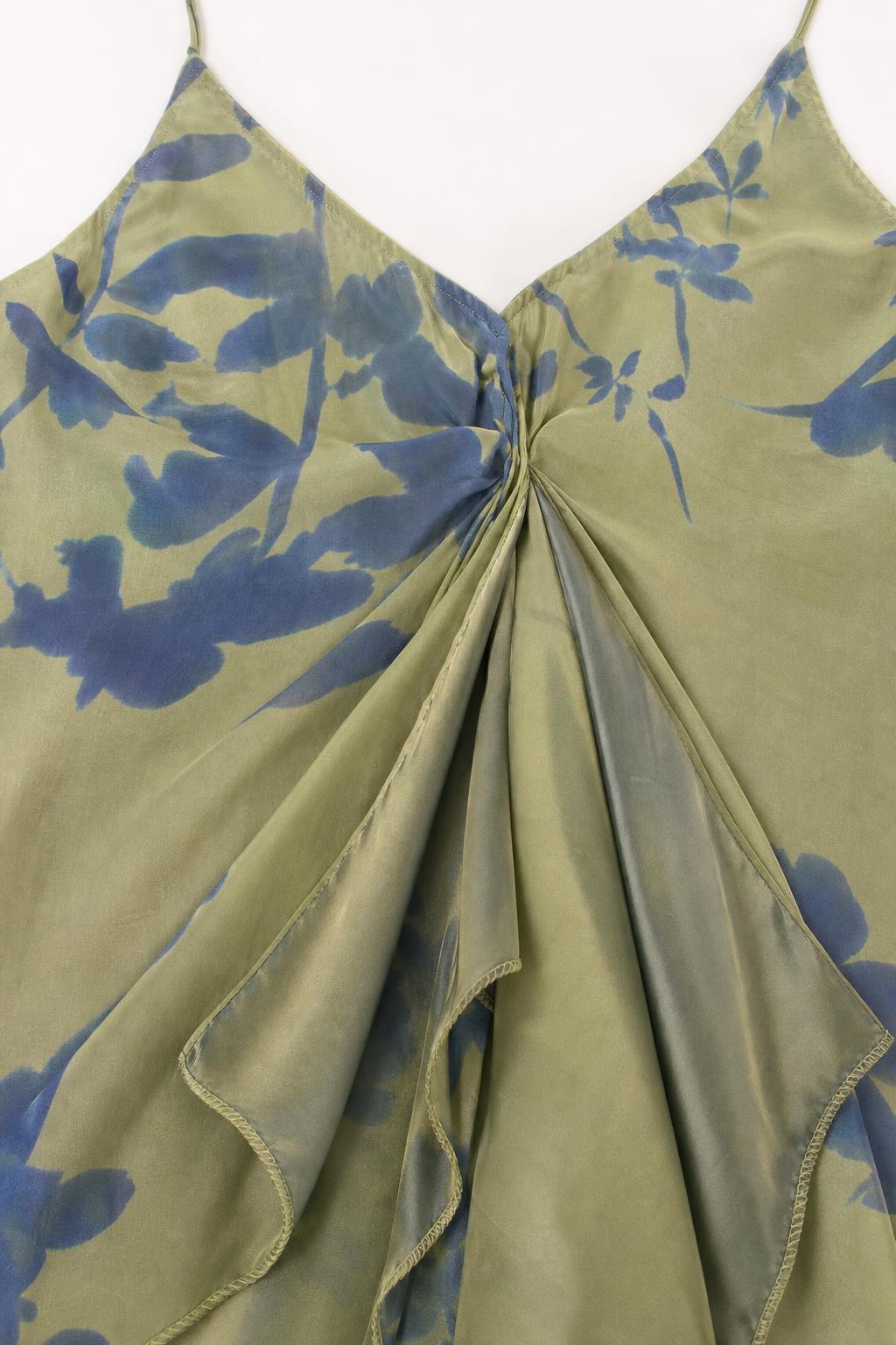 Close-up of fabric and twist-front detail on sage green dress