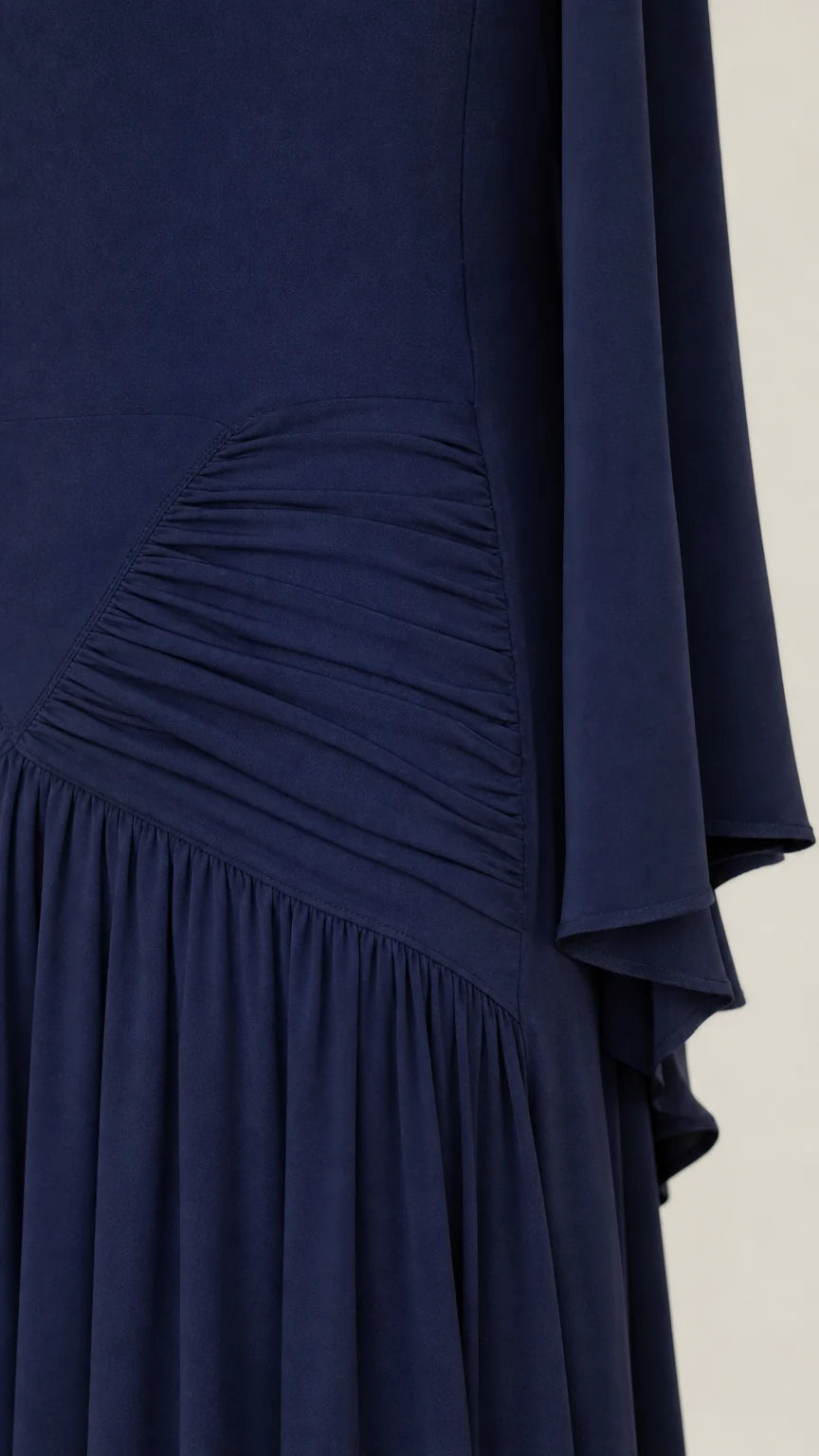 Close-up detail of ruched waist and textured fabric on navy maxi dress