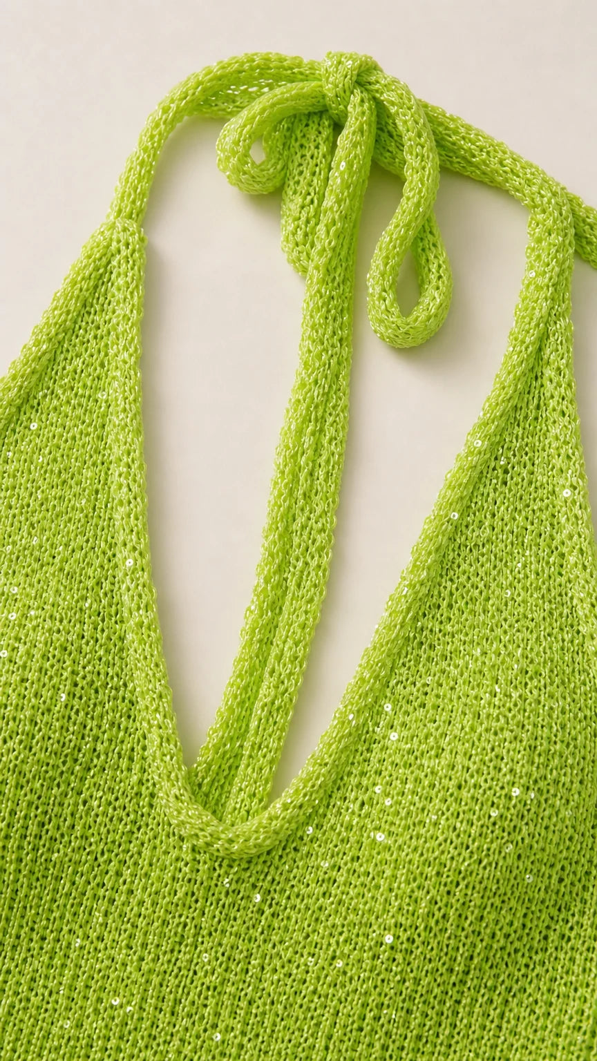 Close-up detail of shimmering neon green knit fabric and halter tie straps