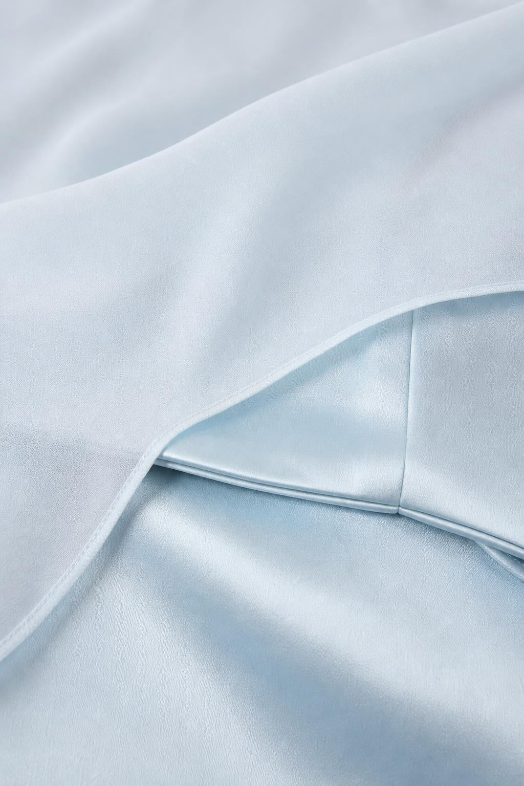 Close-up of light blue satin fabric and sheer overlay texture