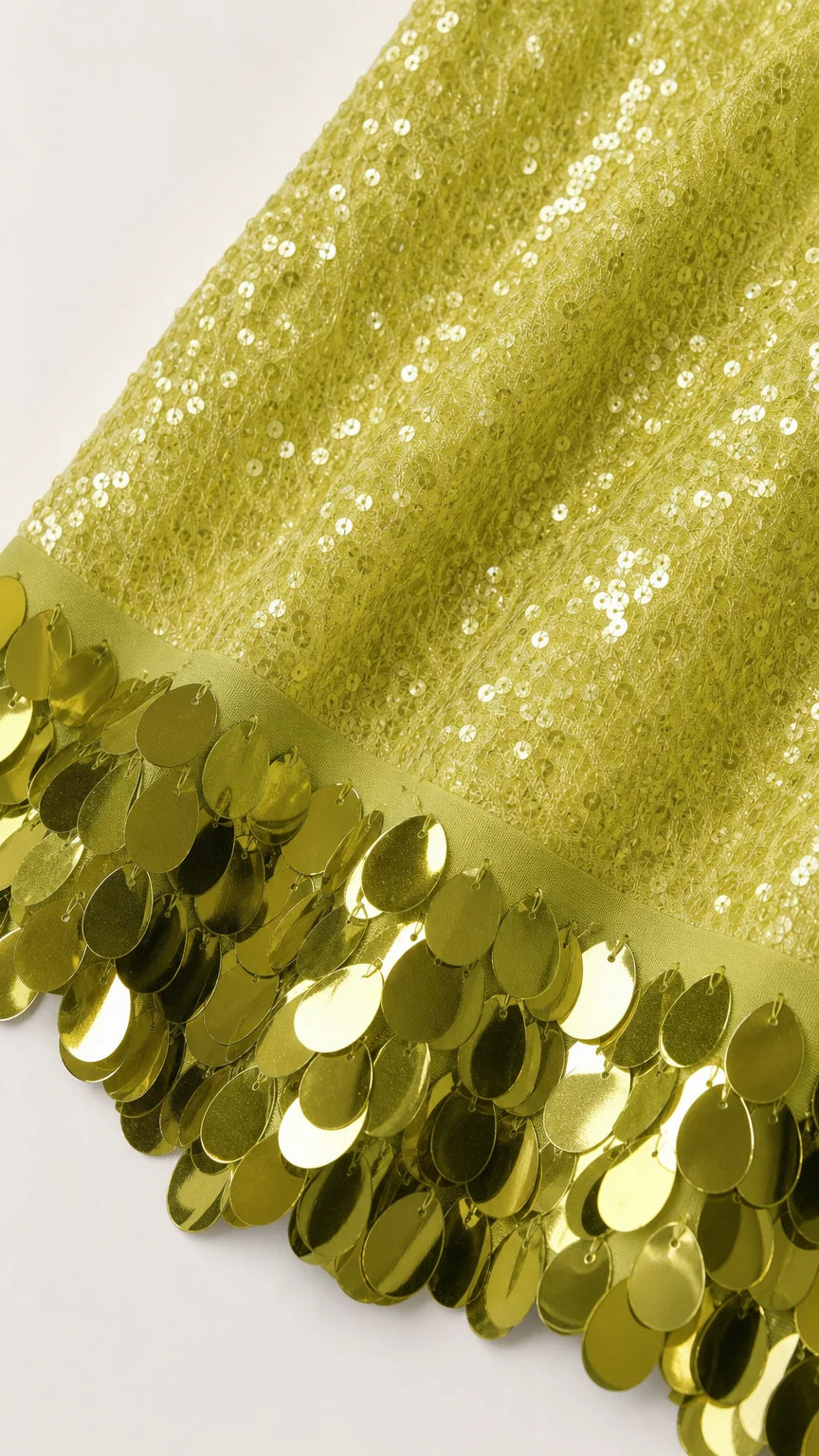 Close-up detail of oversized sequin hem on lime dress